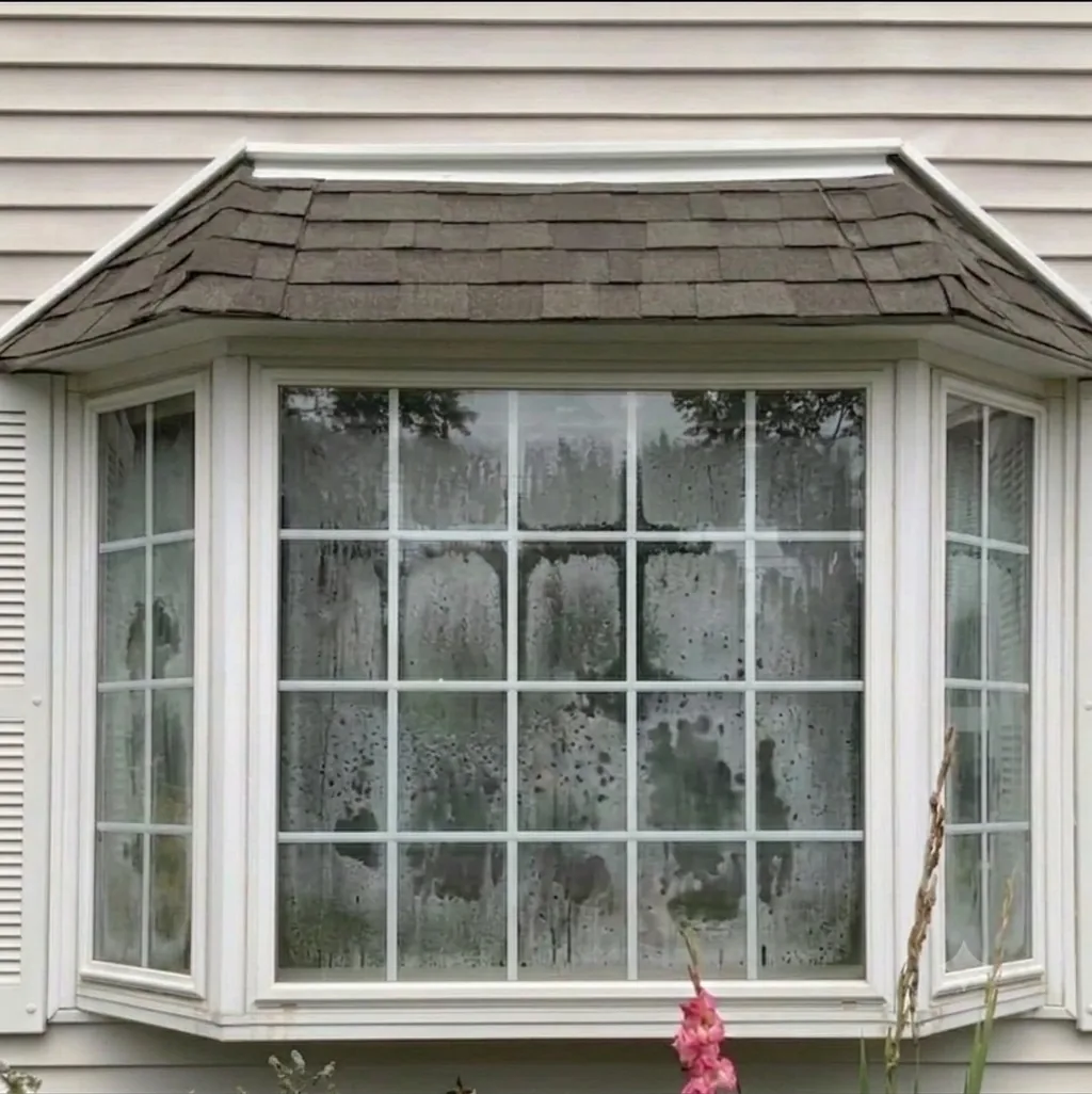 Fogged double-pane window with failed insulated glass seal before repair